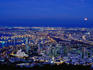 The moon rising over the city of Cape Town and the docks, illuminated at night