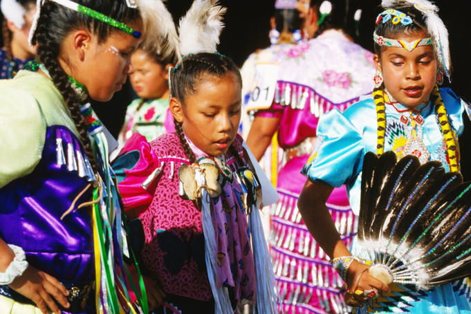 Native AMerican Indian girls in traditional dresses practice dance outside dance competition arena at Mashantucket Pequot Tribal Nation hosted Schemitzun Powwow.