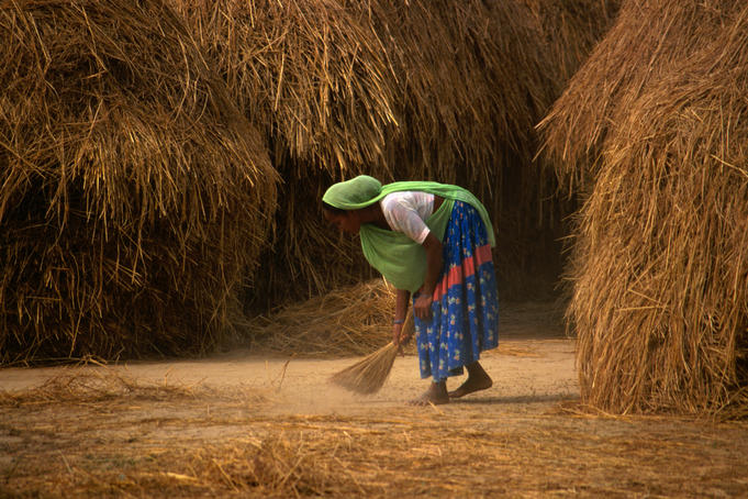 A Tharu woman sweeping.