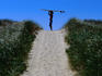 Surfer carrying board on dunes at Long Point.