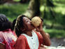 A young girl drinking coconut milk.
