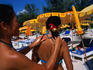 Two Thai women rubbing on suntan lotion.
