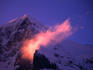 Kleine Scheidegg, the towering Eiger mountain looms in purple sunrise light with streaking ridge clouds.