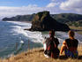 Couple on bluff overlooking black sand beach.