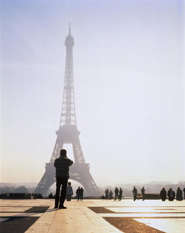 Tourist taking photograph of the Eiffel Tower.