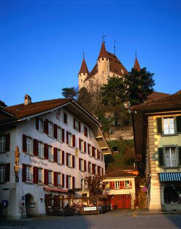 Medieval Castle on hill with cafes in foreground.