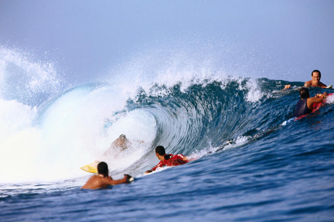 Surfer in the barrel of a wave while others look on, Panaauia.