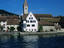 Row boat on the Rhine river in Stein am Rhein with the former Benedictine monastery of St Georgen and 12th century Stadkirche.