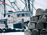 Lobster pots and trawler in snow.