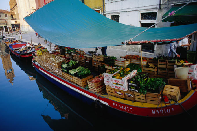 A green grocer sells wares from a 'peata', a type canal boat, on Rio di San Barnaba, Dorsodura.