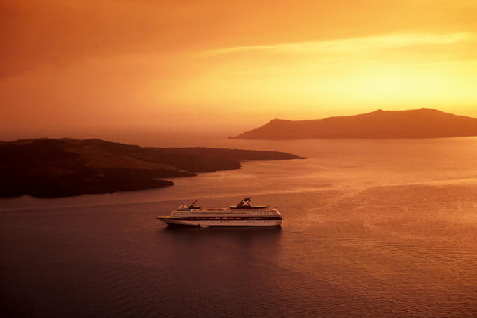 Cruise ship in bay at sunset.