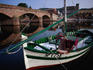 Fishing boat moored near an old bridge (ponte) in Bosa.