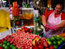 Woman working at juice stand at carmel Market.