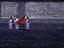 School children standing with flags in front of Mao Zedong Mausoleum on Tiananmen Square.