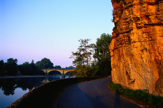 The Cingle de Montfort hugs the limestone cliffs as it idles beside the Dordogne (South-West France).