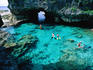 Swimmers snorkelling in rock pools.