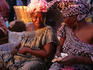 Women in typical dress counting money.
