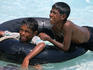 Boys playing in the water with a rubber ring, Mahlos Island.