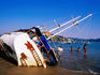 Children playing near a wrecked yacht on Principal Beach.