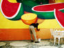 Man painting a wall with a mural.