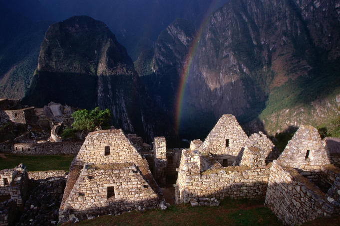 Rainbow over the remaining stone structures in the city sector of Machu Picchu.