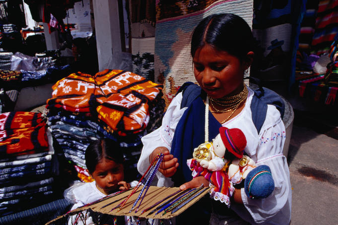 Otavaleno Indian children selling friendship bracelets and dolls at the Poncho Plaza in Otavalo.