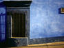 Barred window in painted building, Calle de Allende.