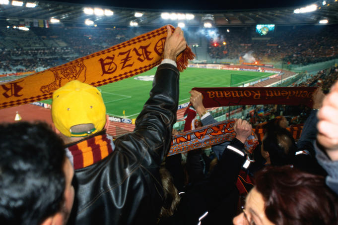 Soccer fans waving scarves at AS Roma versus Ajax Amsterdam match at Champions League Game Stadio Olimpico.
