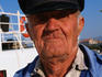 Portrait of old sailor in harbour.