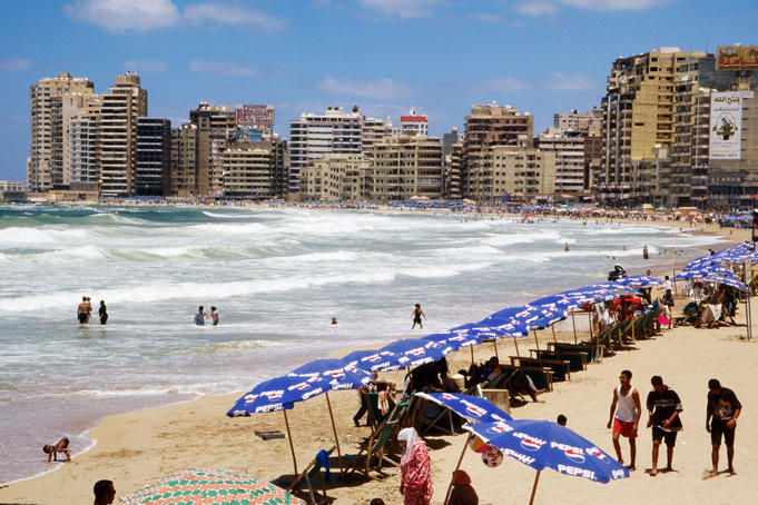 Beachgoers and umbrellas on city beach.