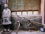 Bicycle parked next to replica terracotta warrior.