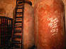 150 year old Budegows, ladder leaning against the large crocks - Sevilla, Andalucia