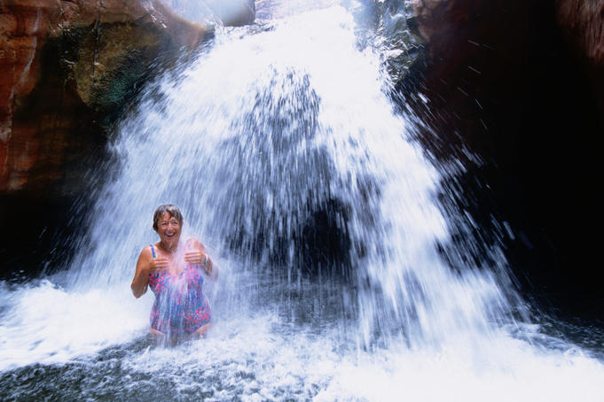 Woman in waterfall at Carbon Creek, Colorado River.