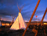 Teepee and American flag glow in sunset at Taos Drum Factory.