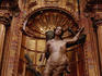 Statue of Saint Sebastian in a gilded niche of a church.