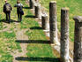 Couple walking past columns in Casermi dei Gladiatori, Old Pompeii.
