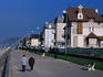 Strollers on beach promenade lined with houses, Cabourg.