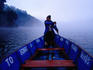 Man paddling boat at dawn.