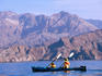 Two people sea kayaking offshore.