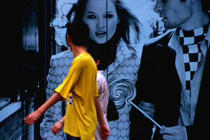 People in front of fashion poster.