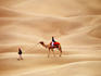 Overhead of Rajasthani men with camel on dunes.