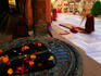 Buddhist prostrates in front of Mahabodhi Temple with Buddha footprints in foreground.