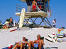 Sunbathers with lifeguard station in background at Moonlight Beach.