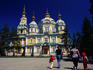 Family walking outside Zenkov Cathedral in Panfilov Park.