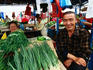 Man selling spring onions in Green Bazar.