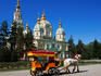 Horse with cart in front of tsarist-era wooden Russian Orthodox church.