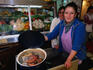 Woman showing Curanto stew at Angelmo fish market.