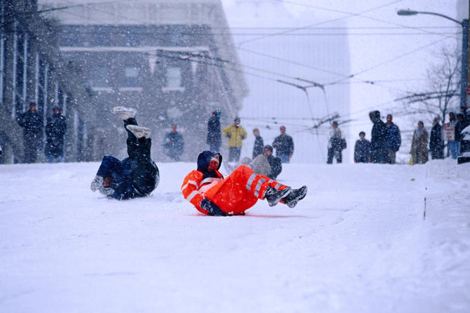 Sliding in the snow on the street.