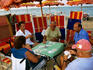 People playing cards under beach umbrella.