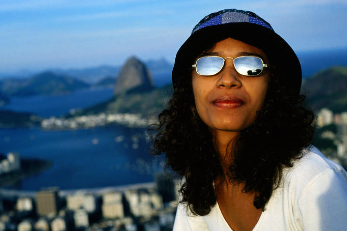 Woman on Corcovado with Guanabara Bay in background.